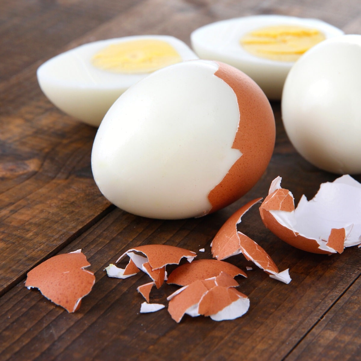 Peeled eggs with shells on table